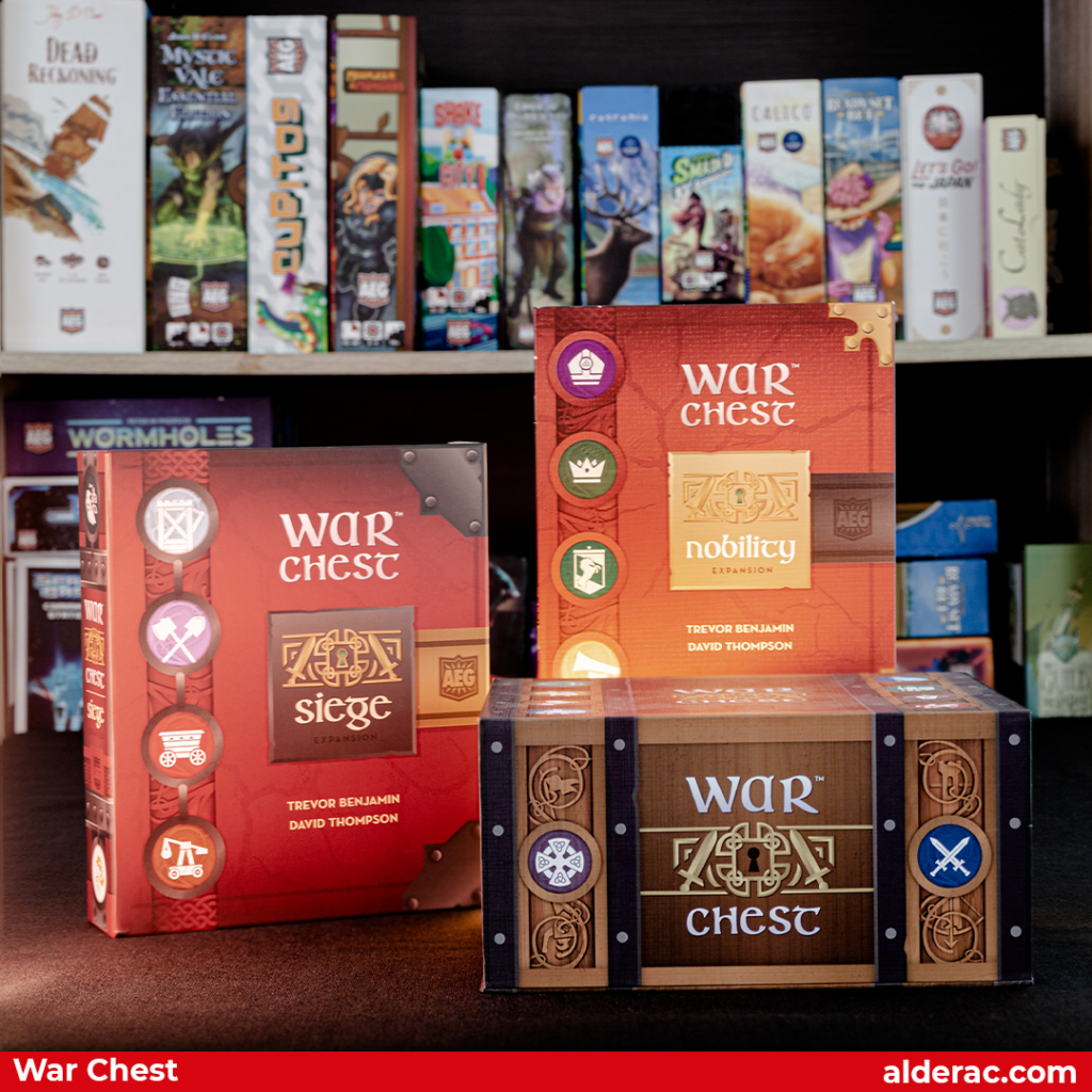 War Chest and expansion boxes with a shelf of boardgames as background